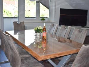 una mesa de comedor con una botella de vino y sillas en Ferienwohnung Wiedergrün, en Durbach