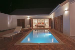 a swimming pool in the middle of a house at Asali Beach House in Jambiani