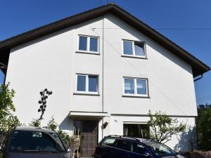 una casa bianca con macchine parcheggiate di fronte di Ferienwohnung Wiedergrün a Durbach