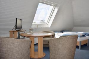 una camera con tavolo, letto e finestra di Gaestehaus Kiekmolrin a Gnarrenburg
