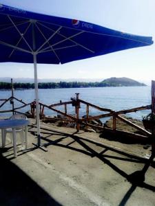 a blue umbrella sitting on a beach next to the water at Nirvana Resort in Sevan