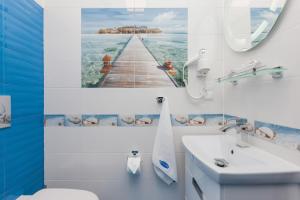 a bathroom with a painting of a pier at VivaLaMer in Pobierowo +72 photos