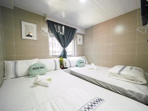 2 camas en una habitación con ventana en Comfort Guest House en Hong Kong