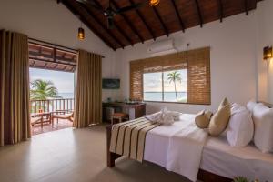 a bedroom with a bed with a view of the ocean at Ananya Beach Resort in Tangalle