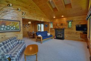 a living room with a couch and a tv and a fireplace at Sandy Shores Condo in Namekagon
