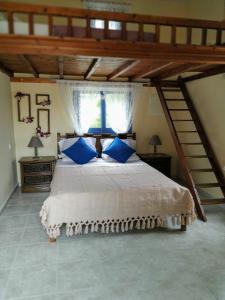 a bedroom with a large bed with blue pillows at Zoes House in Kyra Panagia