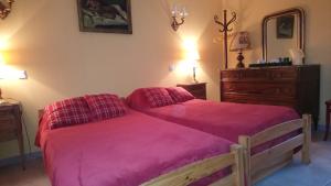 a bedroom with a large bed with a pink blanket at Domaine du Planas AILHON ARDECHE in Ailhon