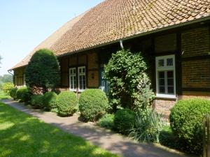 Ein Haus mit Büschen davor. in der Unterkunft Duschenhof in Fuhrberg