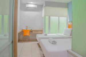 um banheiro branco com banheira e pia em LeGreen Suite Poso em Jacarta