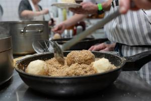 een persoon die voedsel kookt in een pan op een aanrecht bij Gasthof Böhm in Persenbeug