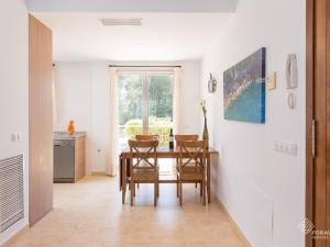 a kitchen and dining room with a table and chairs at Vaumera f in Sa Pobla