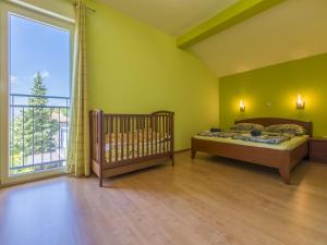 ein Schlafzimmer mit einem Kinderbett und einem großen Fenster in der Unterkunft BRUNO in Crikvenica
