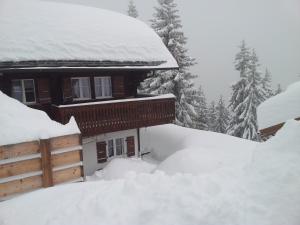 een besneeuwd huis met een berg sneeuw eromheen bij Chalet Grazia in Riederalp
