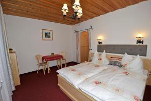 een slaapkamer met een groot bed en een tafel bij Tonnerhof in Schladming