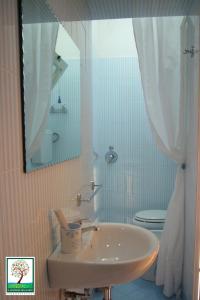 bagno con lavandino, servizi igienici e specchio di Il Giardino Delle Sete a Mesagne