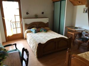1 dormitorio con cama de madera y 2 almohadas en Mountain Vacances - Maison Rachou, en Lanne-en-Barétous 