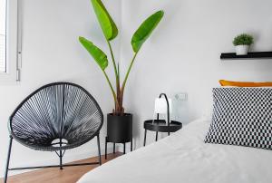 ベニカルロにあるEdificio Belの椅子と植物のあるベッドルーム