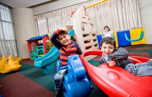 two young boys playing on slides in a playground at Yiwu Ocean Hotel - Original Best Western Premier Ocean Hotel in Yiwu