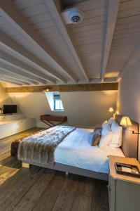 a large bed in a room with a wooden ceiling at Chateau Beausaint in La-Roche-en-Ardenne