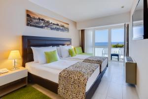 a bedroom with a bed with a view of the ocean at Hotel Pinija in Petrcane