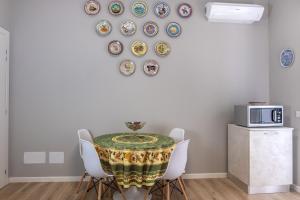 La Nuova Corte Rooms في فيرونا: غرفة طعام مع طاولة وكراسي وأطباق على الحائط