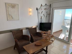 sala de estar con TV, sillas y mesa en AwayDays - 94 - Appartement 1 Chambre Vue Mer en Empuriabrava