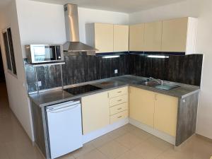 a kitchen with a sink and a microwave at AwayDays - 94 - Appartement 1 Chambre Vue Mer in Empuriabrava