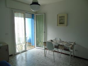 una stanza con tavolo e sedie in una stanza con porta di Residenza Sporting a Lignano Sabbiadoro