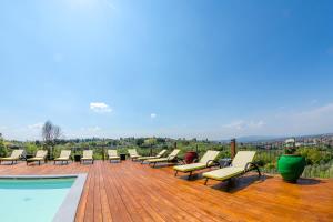 a row of lounge chairs on a deck next to a pool at Villa Tolomei Hotel & Resort in Florence