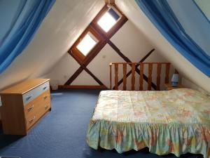 - une chambre mansardée avec un lit et une fenêtre dans l'établissement La Maison Jaune, à Ammerschwihr