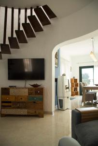 ein Wohnzimmer mit einem Flachbildfernseher an der Wand in der Unterkunft Torre Orquidaceae - Plus Costa Brava in L'Estartit