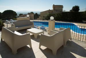 eine Terrasse mit Stühlen, einem Tisch und einem Pool in der Unterkunft Torre Orquidaceae - Plus Costa Brava in L'Estartit