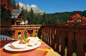 una mesa con un plato de comida y dos copas de vino en Gasthof Meierei, en Carezza al Lago