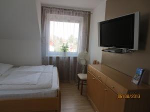 a bedroom with a bed and a tv and a window at Bella Vita in Rust