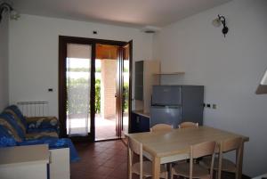 a kitchen and dining room with a table and a refrigerator at Agriresidence San Pietro in Bibione