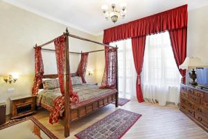 a bedroom with a canopy bed with red curtains at Hotel Regal 1880 - Boutique Hotel in Parcul Central Sinaia in Sinaia