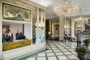 a lobby with two people standing at a reception desk at Grand Hotel Santa Lucia in Naples