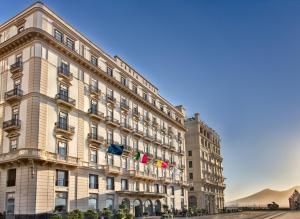 a large building with a flag on top of it at Grand Hotel Santa Lucia in Naples