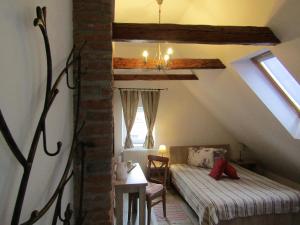 a attic room with a bed and a table and a window at Blue House in Braşov