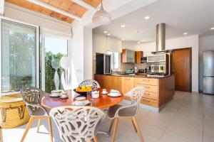 a kitchen with a wooden table and chairs in a room at Villa Can Fluxa in Ibiza Town