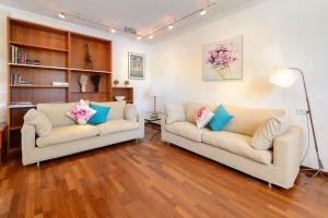 2 sofás blancos en una sala de estar con suelo de madera en Villa Can Fluxa, en Ibiza