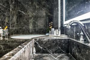 a black marble bathroom with a tub and a sink at Grand Hotel Santa Lucia in Naples +32 photos