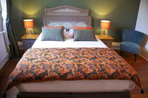 a bedroom with a bed with an orange and blue comforter at La bohème - Chambres d’hôtes in Senlis