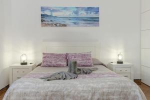 a white bedroom with a bed with two night stands at Buda in Tinajo