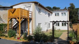 una casa con una terraza a un lado en Ferienwohnungen Villa Waldblick, en Zempin