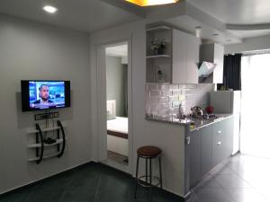 a kitchen with a tv on a wall with a counter at Apartment Eteri in Batumi