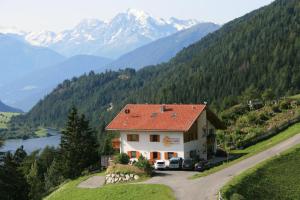 a house on a hill with mountains in the background at Appartement Sunnleitn in San Valentino alla Muta