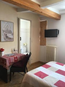 a bedroom with a bed and a tv on the wall at Les Gentianes in Allos