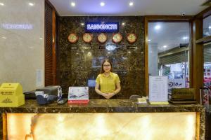a woman standing behind a counter in a restaurant at Saigonciti Hotel A in Ho Chi Minh City