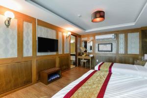 a bedroom with a bed and a flat screen tv at Saigonciti Hotel A in Ho Chi Minh City